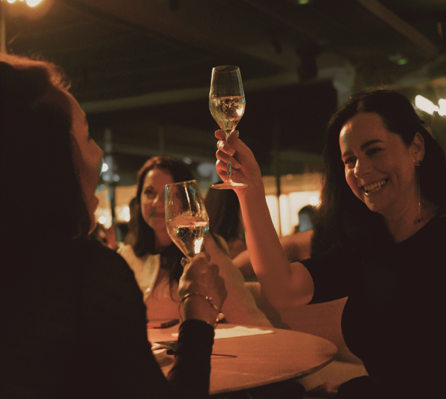 Compañeras brindando con vino en una cena de empresa en Sabbia