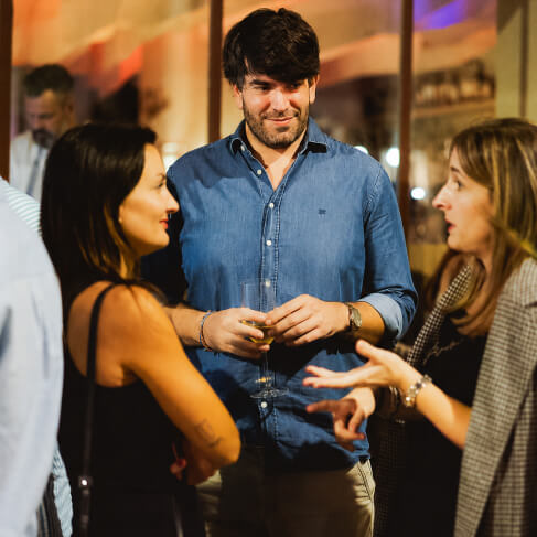 Invitados charlando con copas de vino en una cena de empresa en Sabbia