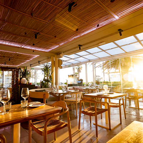 Sala del restaurante Sabbia con mesas de madera y luz cálida
